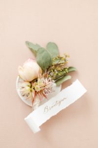 Hochzeitsfotograf Berlin: Hochzeitsdetails Bild mit Anstecker vom Bräutigam - Fine Art Papeterie